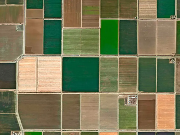 Vista aérea de parcelas agrícolas con una parcela dibujándose sobre el mapa